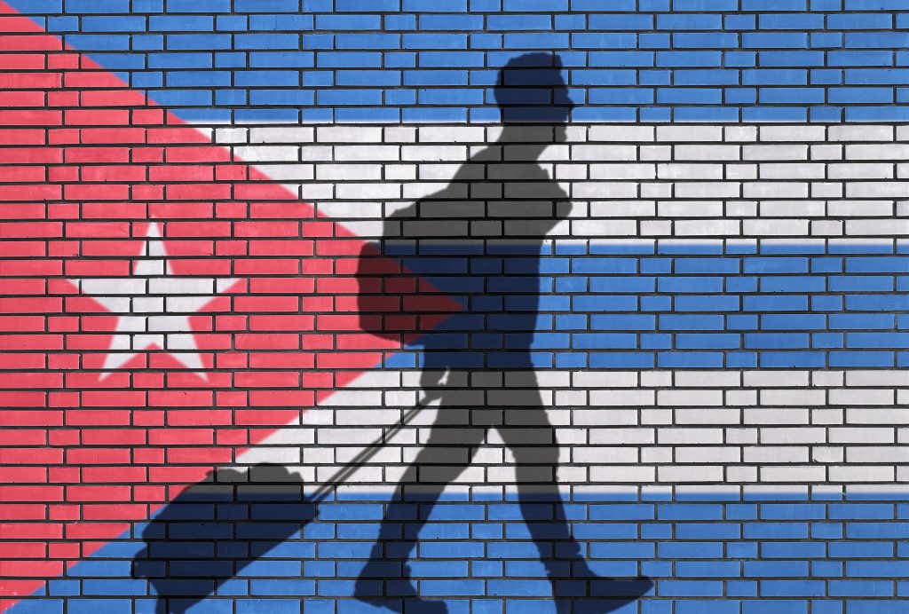 Cuban-Flag-behind-man-with-Suitcase-1024x692